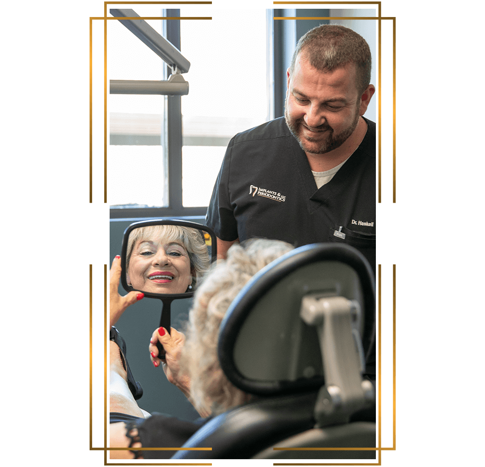 Dr. Haskell. giving a mirror to a patient to see their teeth