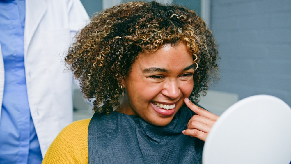 young women smiling into a mirror